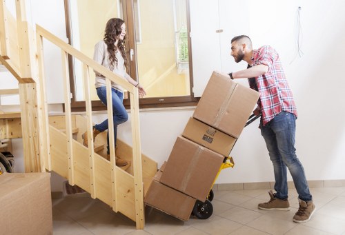 Professional movers unloading household items at a new home in Staines